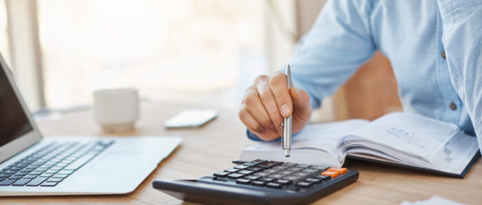 close-up-detail-professional-serious-accountant-sitting-light-office-checking-company-finance-profits-calculator 1